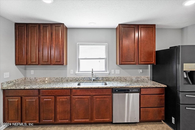 kitchen featuring a textured ceiling, light stone countertops, appliances with stainless steel finishes, and sink