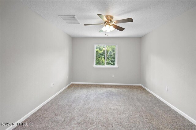 unfurnished room with a textured ceiling, ceiling fan, and carpet