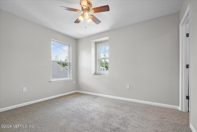 empty room with ceiling fan, carpet, and a textured ceiling