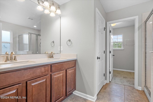 bathroom featuring tile patterned floors, an enclosed shower, and vanity