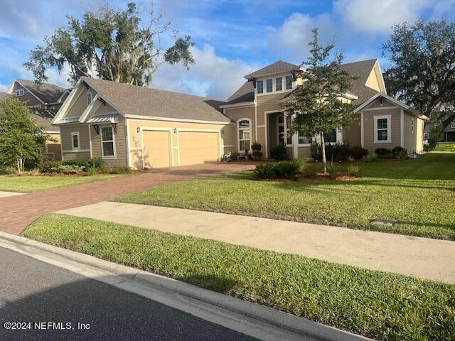 view of front of home with a garage and a front lawn