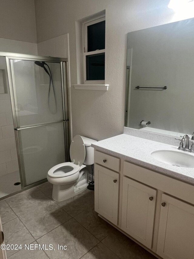 bathroom featuring an enclosed shower, tile patterned flooring, toilet, and vanity