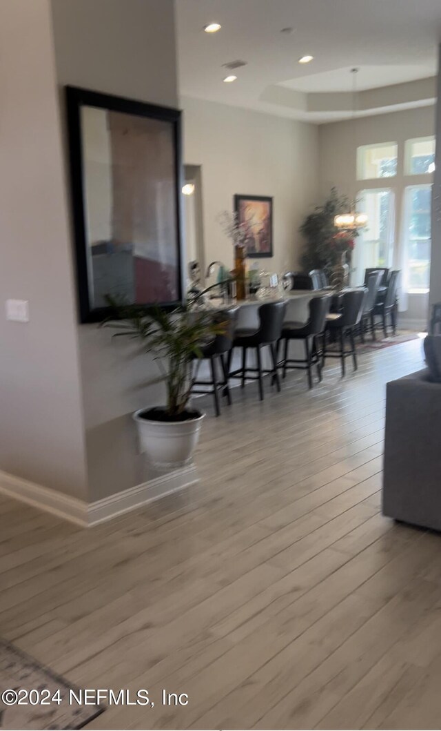 dining area featuring wood-type flooring and a raised ceiling