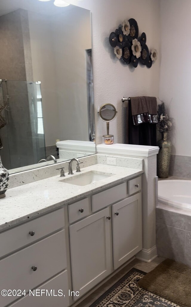 bathroom with vanity and shower with separate bathtub