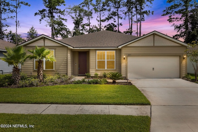 single story home featuring a yard and a garage