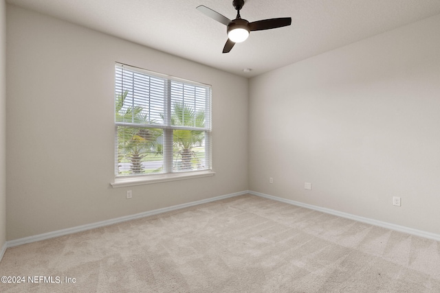 spare room with ceiling fan and light carpet