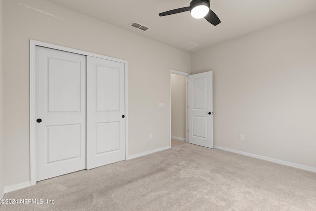 unfurnished bedroom featuring light colored carpet, ceiling fan, and a closet