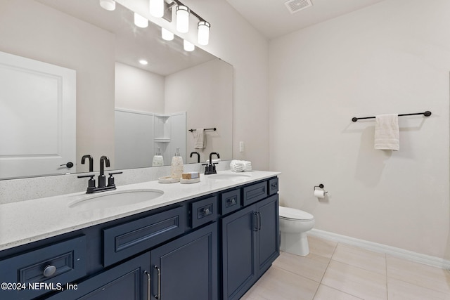 bathroom featuring tile patterned floors, toilet, vanity, and a shower