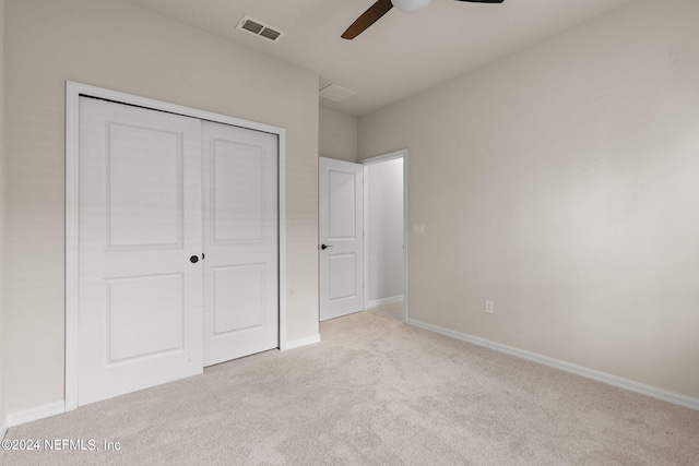 unfurnished bedroom featuring light carpet, a closet, and ceiling fan