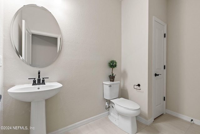 bathroom featuring tile patterned floors, toilet, and sink