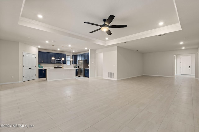 unfurnished living room featuring ceiling fan, a tray ceiling, and light tile patterned floors