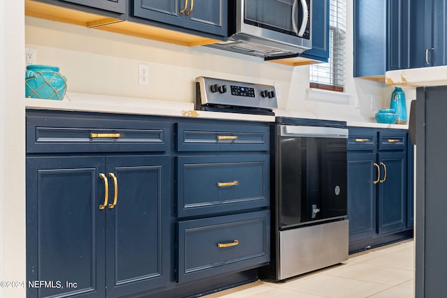 kitchen featuring blue cabinetry, appliances with stainless steel finishes, and light tile patterned floors