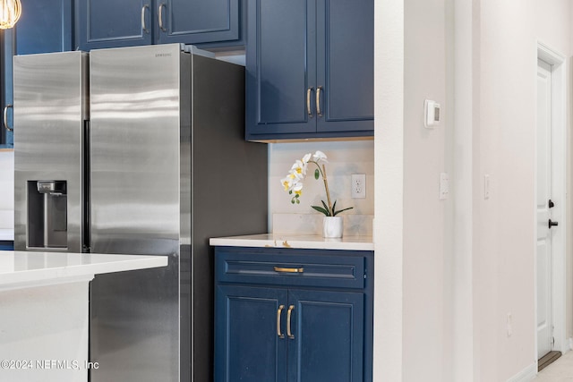 kitchen with blue cabinets and stainless steel refrigerator with ice dispenser