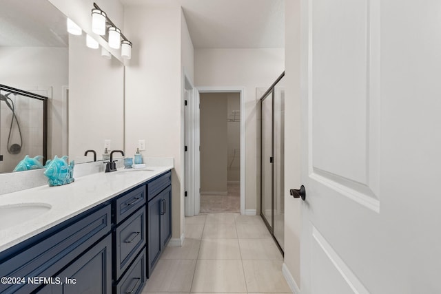 bathroom featuring vanity, a shower with shower door, and tile patterned floors