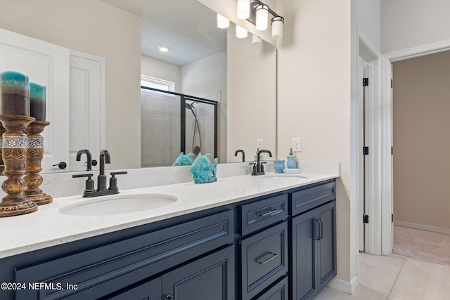 bathroom featuring vanity, a shower with shower door, and tile patterned flooring