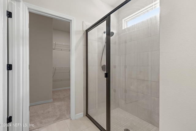 bathroom featuring a shower with shower door and tile patterned flooring