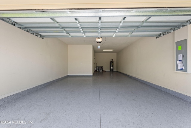 garage with a garage door opener, electric panel, and electric water heater