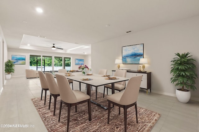 dining area featuring light tile patterned floors, ceiling fan, and a tray ceiling