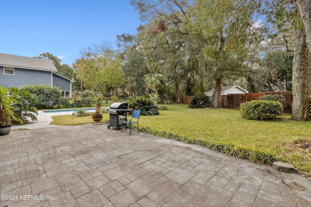 view of patio / terrace featuring a fenced in pool and area for grilling