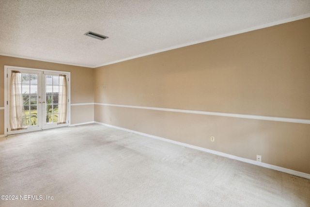 spare room with french doors, carpet floors, a textured ceiling, and crown molding