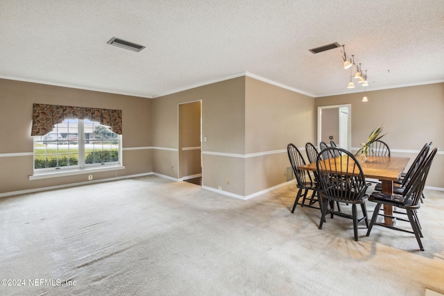 dining area with light colored carpet, ornamental molding, a textured ceiling, and track lighting