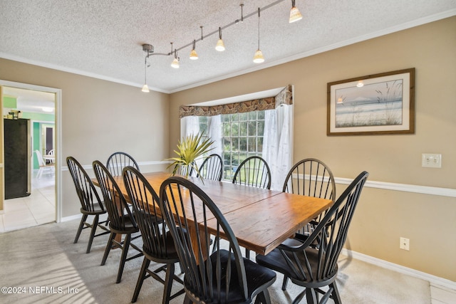 dining room with light tile patterned floors, a textured ceiling, rail lighting, and ornamental molding