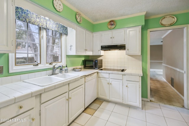 kitchen with tile countertops, dishwasher, sink, light tile patterned floors, and white cabinetry