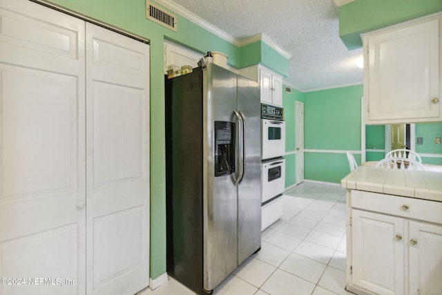 kitchen featuring white double oven, white cabinets, light tile patterned floors, tile counters, and stainless steel fridge with ice dispenser