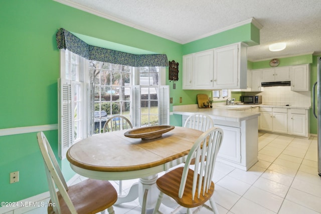 dining space with light tile patterned flooring, sink, ornamental molding, and a textured ceiling