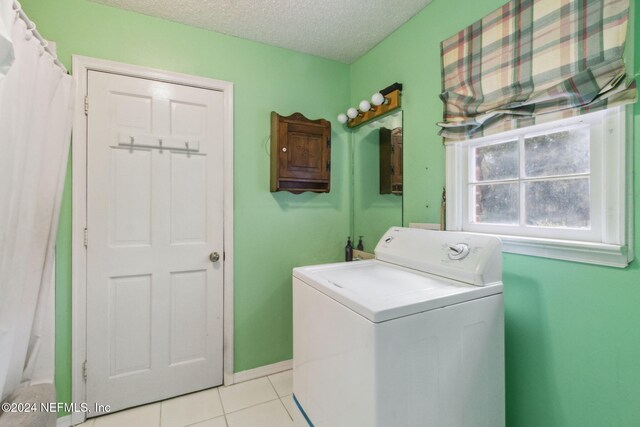 laundry area featuring washer / dryer, a textured ceiling, and light tile patterned floors