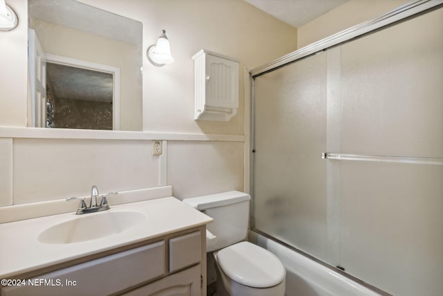 full bathroom with vanity, toilet, and enclosed tub / shower combo