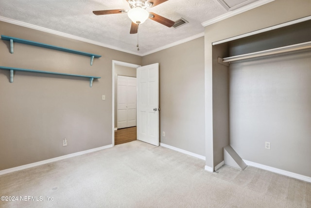 unfurnished bedroom with light carpet, ceiling fan, ornamental molding, a textured ceiling, and a closet