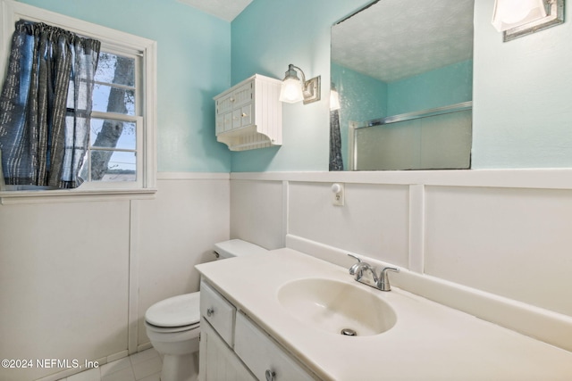 bathroom featuring tile patterned floors, a textured ceiling, an enclosed shower, toilet, and vanity