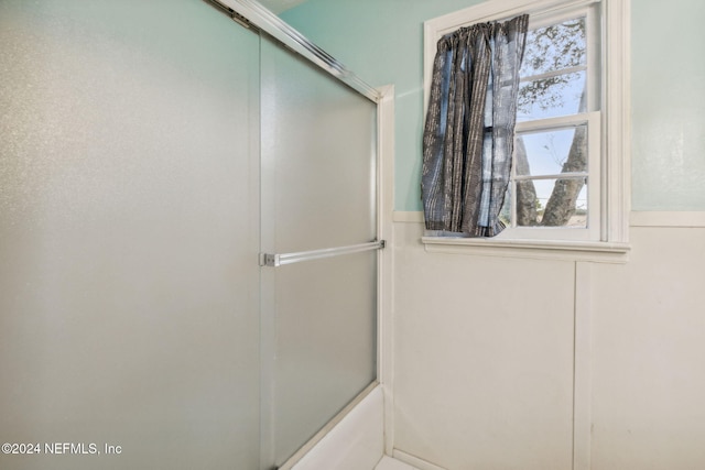 bathroom with combined bath / shower with glass door