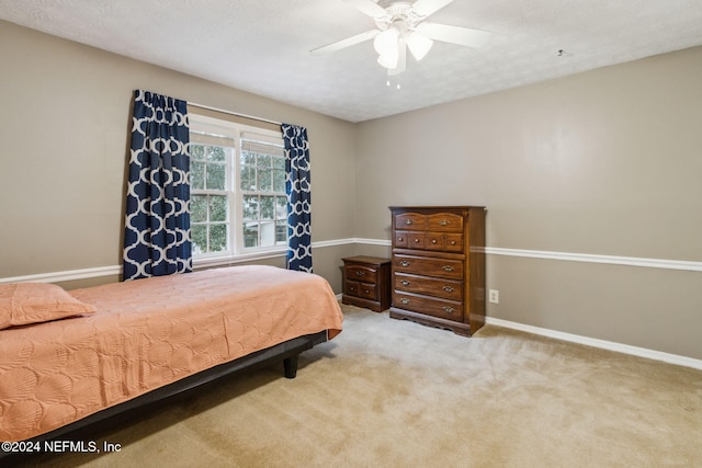 carpeted bedroom featuring a textured ceiling and ceiling fan