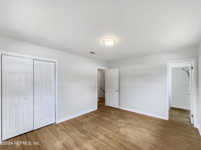 unfurnished bedroom with hardwood / wood-style floors and a closet