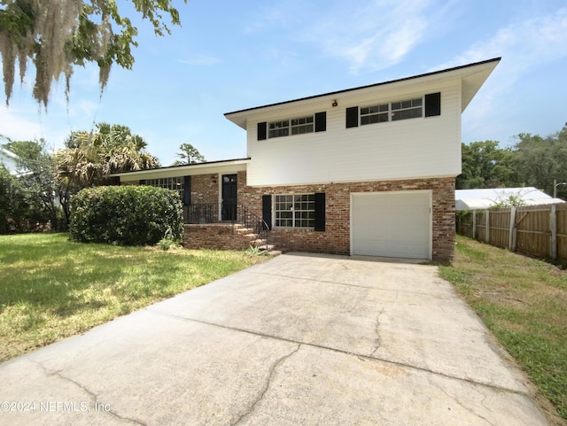 split level home with a garage and a front lawn