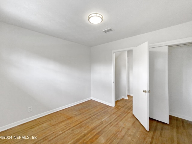 unfurnished bedroom with a closet and light hardwood / wood-style flooring