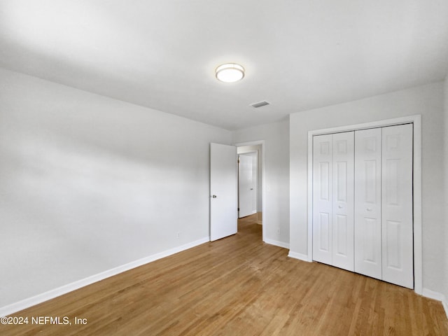 unfurnished bedroom with a closet and light hardwood / wood-style flooring