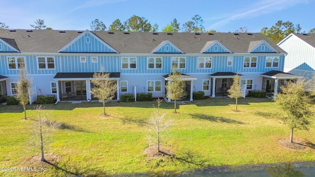 back of property featuring a lawn and board and batten siding