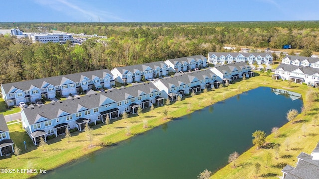 birds eye view of property with a forest view, a residential view, and a water view