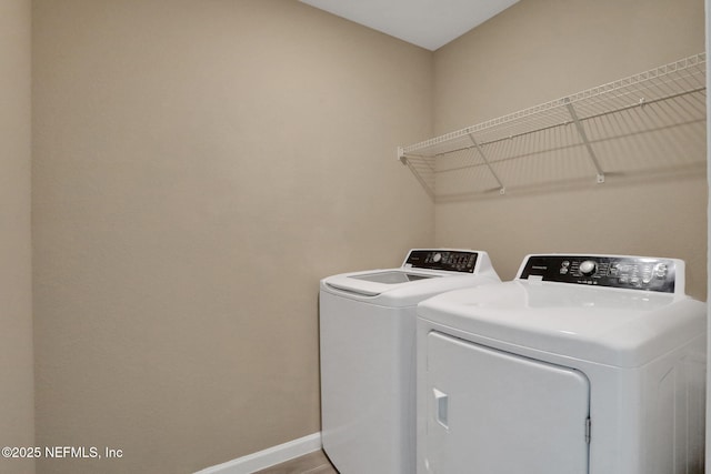 washroom featuring laundry area, baseboards, and independent washer and dryer