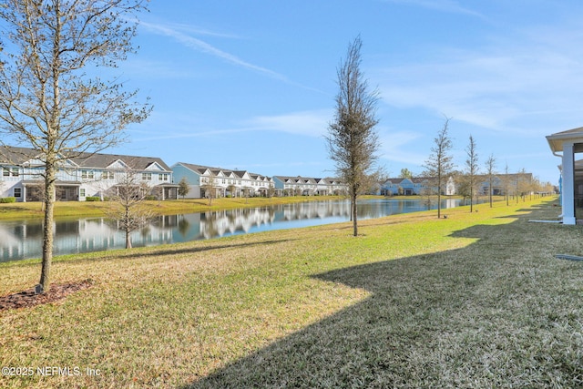 view of yard with a residential view and a water view