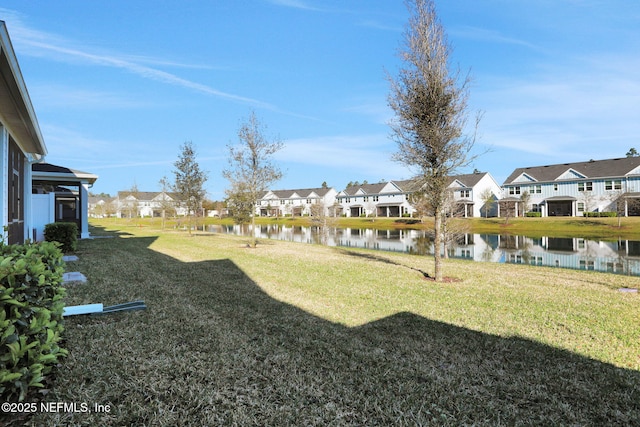 view of yard featuring a residential view and a water view