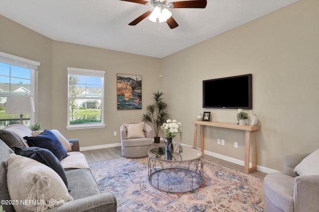 living room with baseboards, wood finished floors, and a ceiling fan