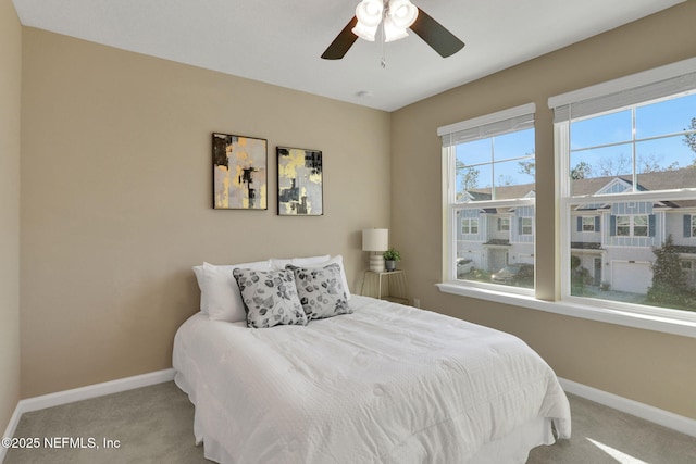 bedroom with a ceiling fan, baseboards, and carpet floors