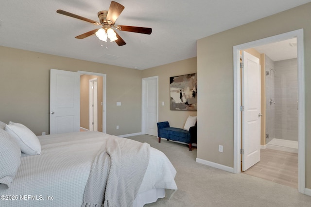 bedroom featuring ceiling fan, baseboards, ensuite bathroom, and light carpet