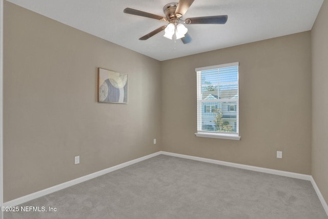 carpeted empty room with ceiling fan and baseboards