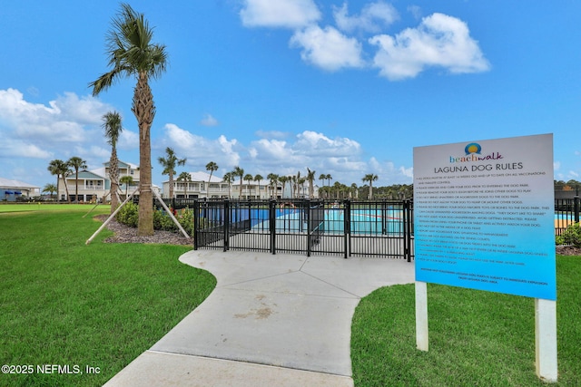 view of home's community with a lawn and fence