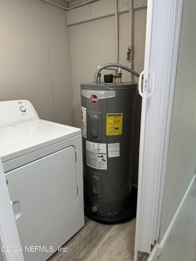 laundry area with electric water heater, washer / dryer, and light hardwood / wood-style flooring